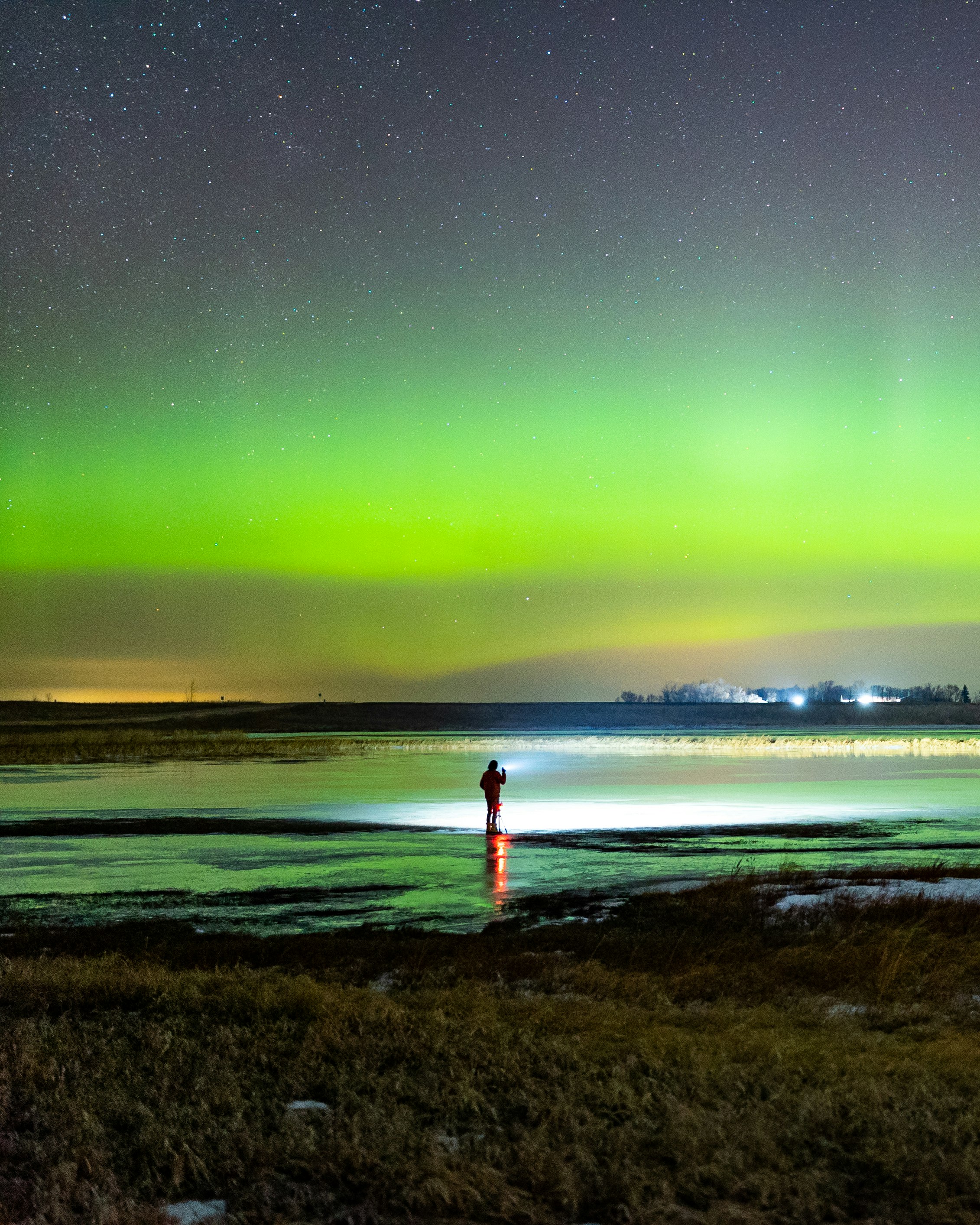 person in red shirt standing on seashore during night time